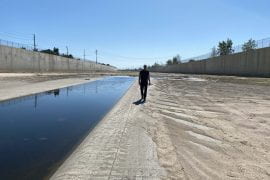 <p>“The impacts of a severe flood would not be evenly distributed across Angelinos. Disadvantaged communities are disproportionately affected, and they’re less well protected,” says Brett Sanders, UCI professor of civil and environmental engineering, here walking in the Santa Ana River channel. Jo Kwon / Spectrum News </p>
